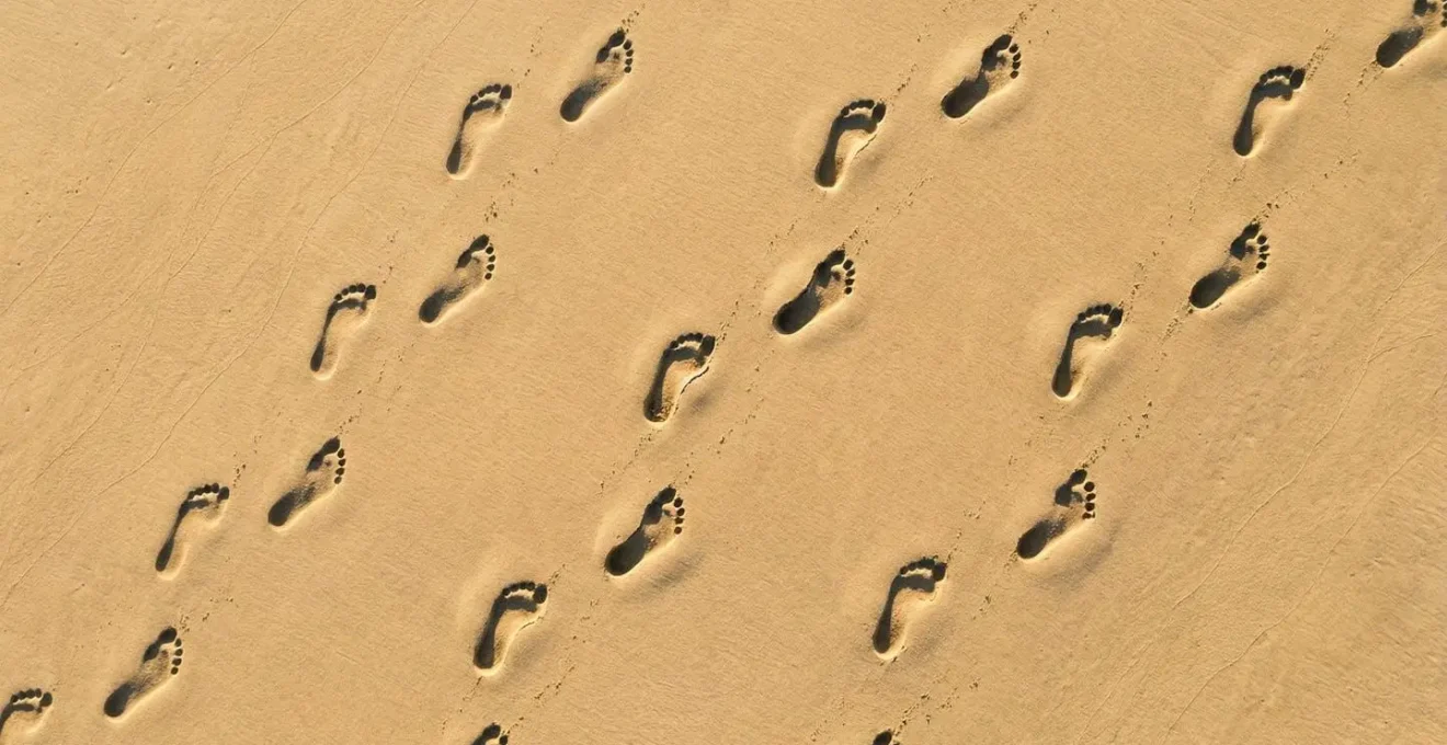 Vue aérienne d'empreintes de pas dans le sable montrant différents types d'appuis : pronateur, neutre et supinateur.