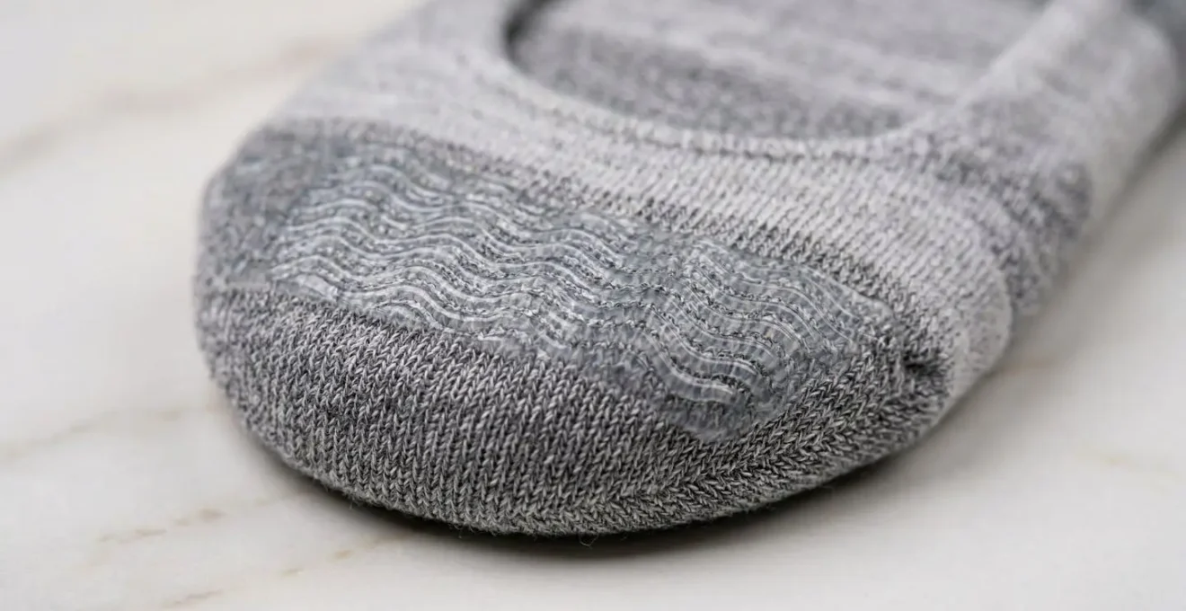 Gros plan macro sur le talon d'une chaussette invisible montrant la bande de silicone