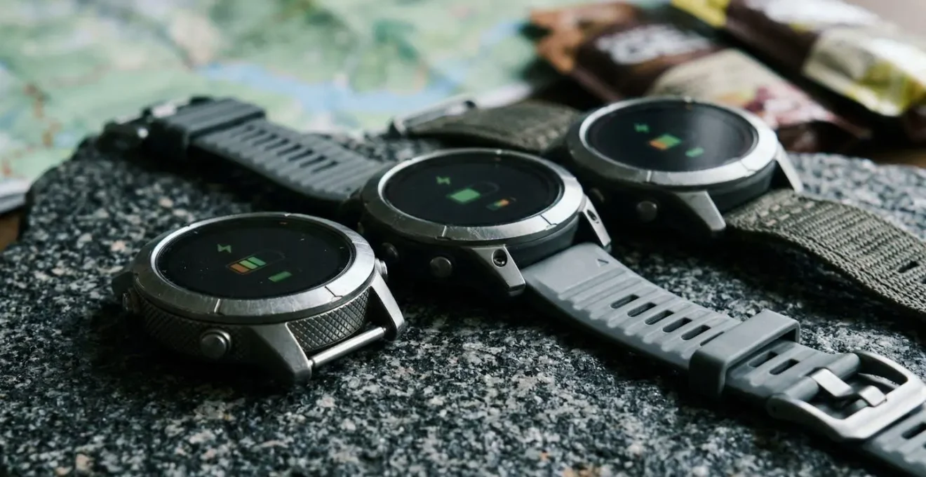 Trois montres GPS alignées montrant différents niveaux de batterie
